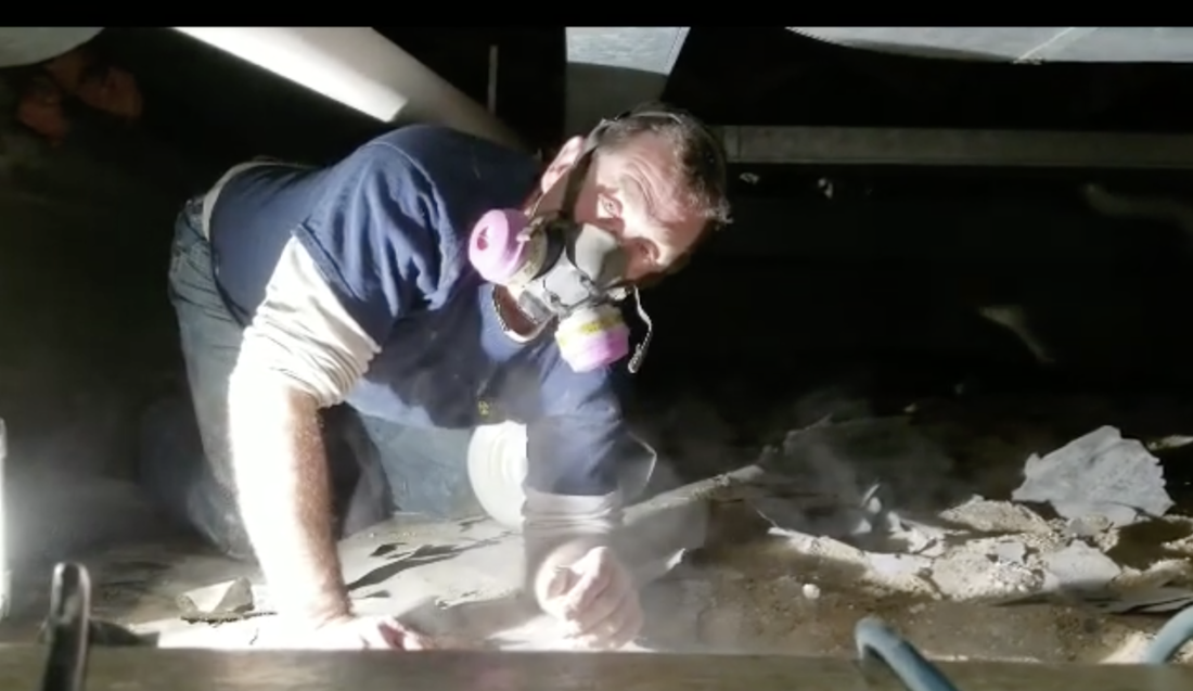 A Lexington Kentucky man in a homes crawlspace testing for radon