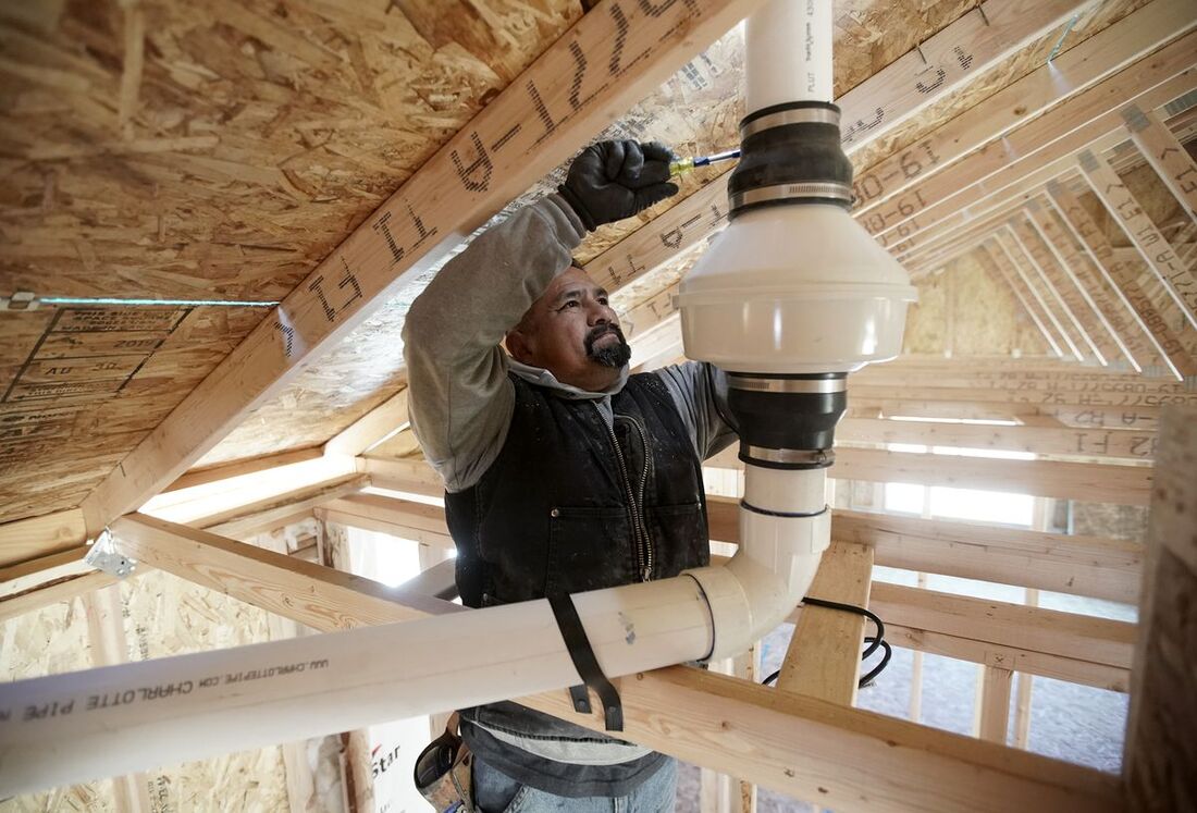 A Winchester KY man installing a radon reduction system in a houses attic